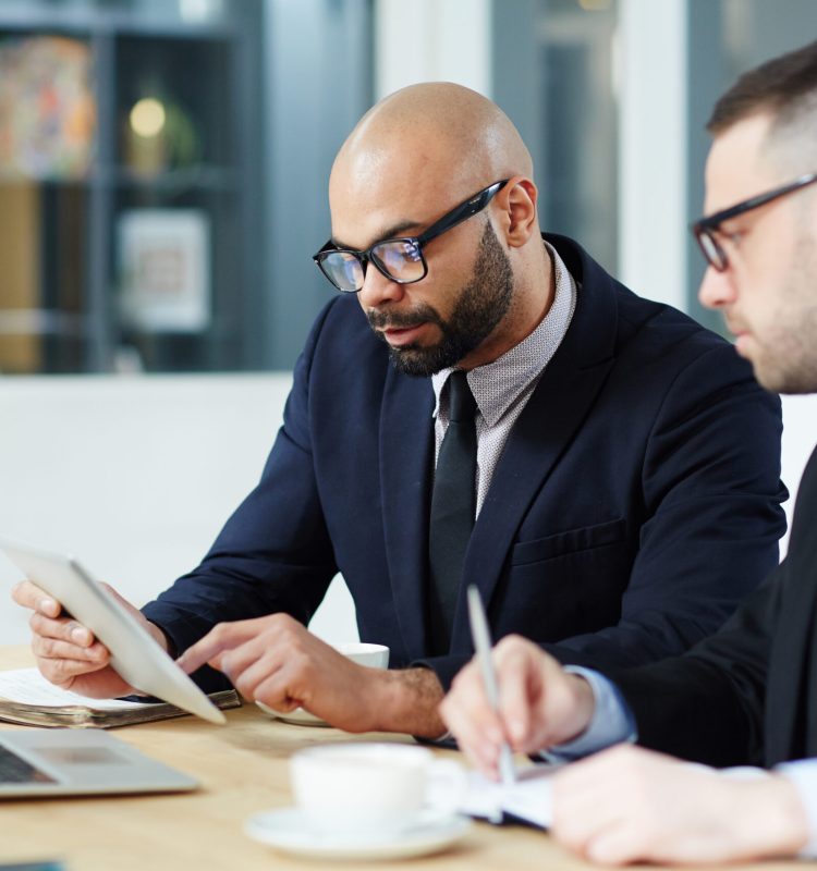 Two men in suits learning financial statistics in touchpad
